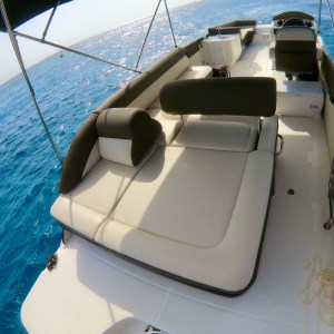 a blue and white boat sitting next to a body of water