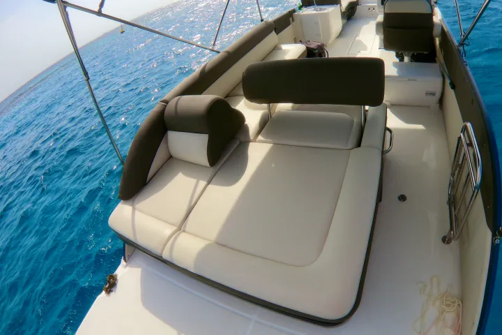 a blue and white boat sitting next to a body of water